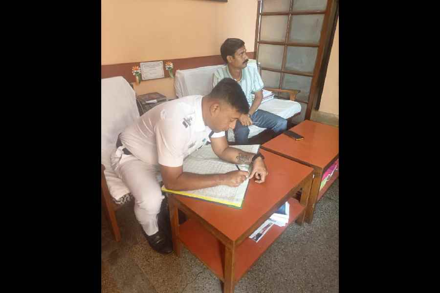 A policeman checks the register of a hotel on Royd Street on Wednesday