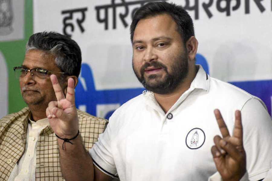 Tejashwi Yadav flashes victory sign during a news conference in Patna on Wednesday.