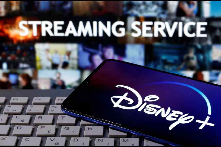 A smartphone with displayed "Disney" logo is seen on the keyboard in front of displayed "Streaming service" words in this illustration taken March 24, 2020.