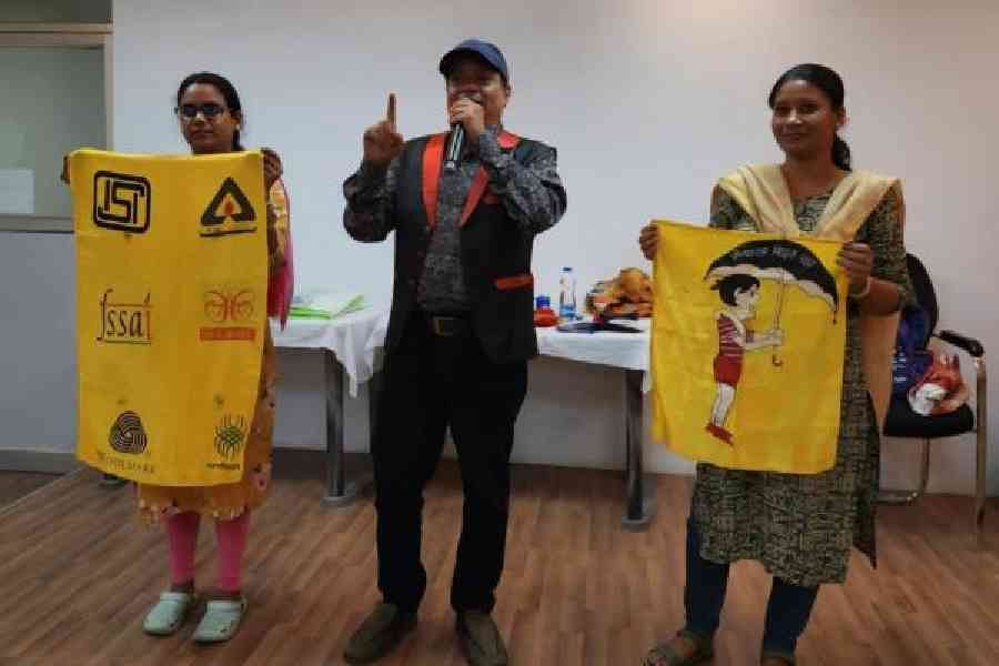 A magician makes two banners appear with quality mark logos that consumers should look out for when making purchases, at a consumer awareness camp at Vidyasagar Bhavan 