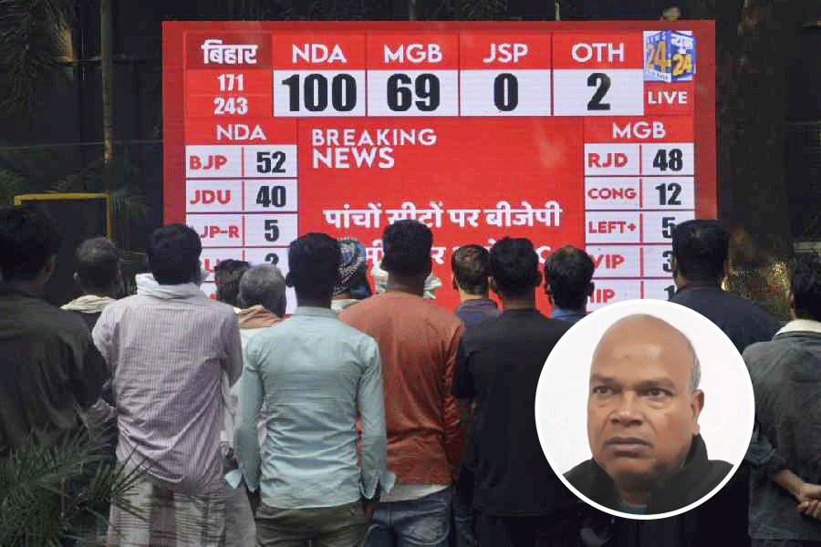 People watch live broadcast of the results of Bihar Assembly elections as vote counting underway, in Patna, Friday, November 14, 2025.