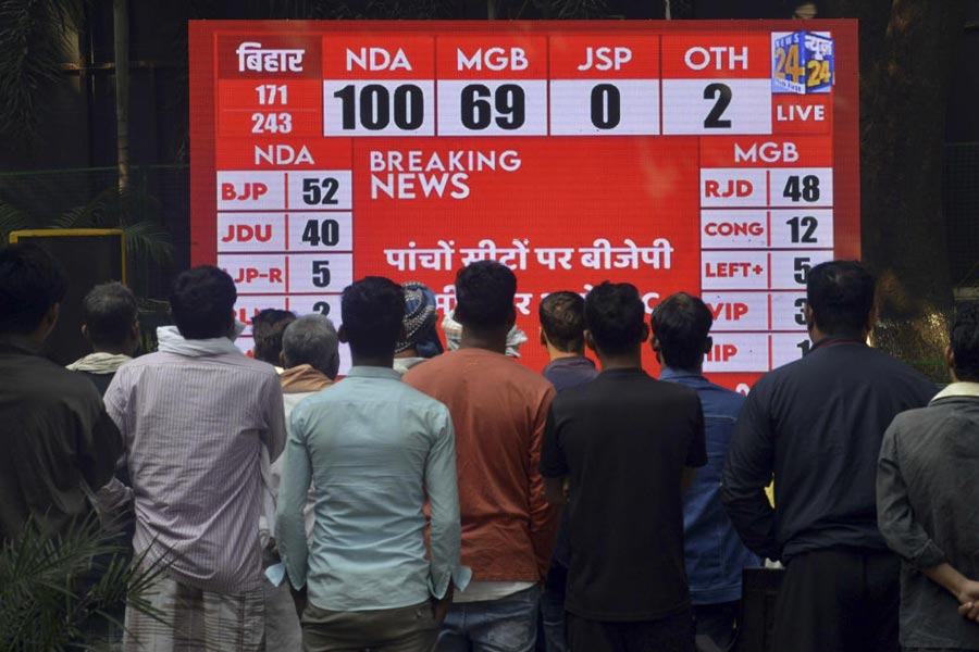 People watch live broadcast of the results of Bihar Assembly elections as vote counting underway, in Patna, Friday, Nov. 14, 2025.