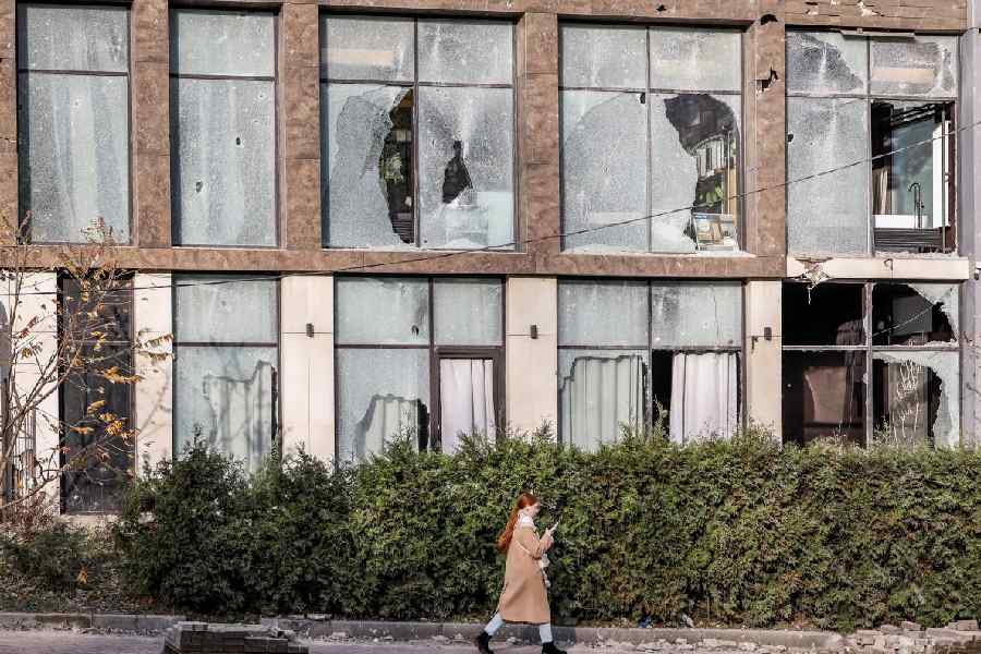 A woman passes by a residential building damaged during an overnight Russian drone and missile strike, amid Russia's attack on Ukraine, in Kyiv, Ukraine, November 14, 2025.