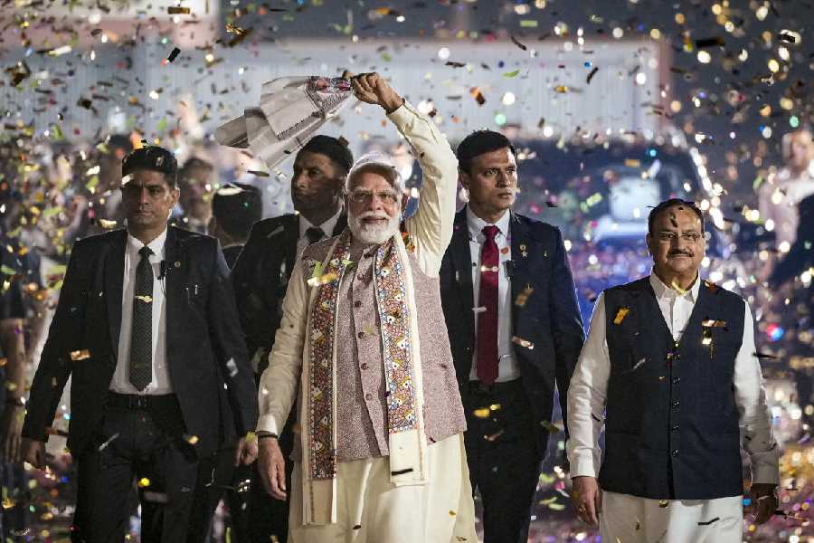Prime Minister Narendra Modi waves a ‘gamcha’ as he arrives during the celebration of NDA’s victory in the Bihar Assembly elections, at BJP headquarters, in New Delhi, Friday, Nov. 14, 2025