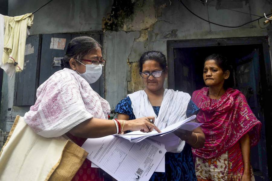 A booth level officer (BLO) explains the details of enumeration form to a voter as the Special Intensive Revision (SIR) of electoral rolls begins in West Bengal, in Kolkata, West Bengal, Tuesday, Nov. 4, 2025.