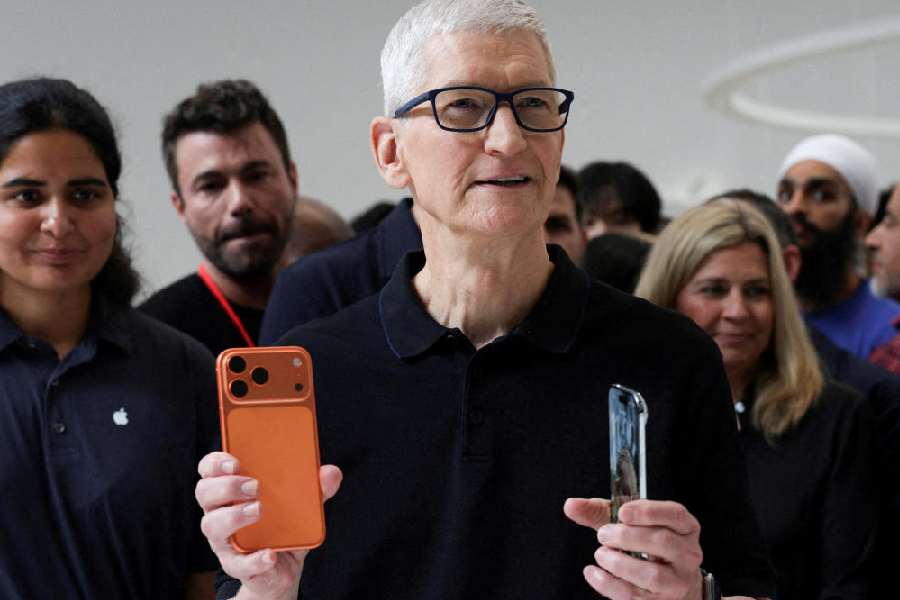 Apple CEO Tim Cook holds an iPhone 17 pro and an iPhone Air