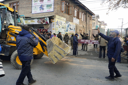 A backhoe loader being brought to clear the debris after an accidental explosion ripped through Nowgam police station on late Friday night