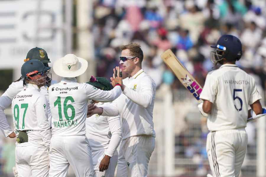 South Africa's Simon Harmer with teammates after the wicket of India's Ravindra Jadeja during the third day of the first Test cricket match of a series between India and South Africa, at Eden Gardens in Kolkata