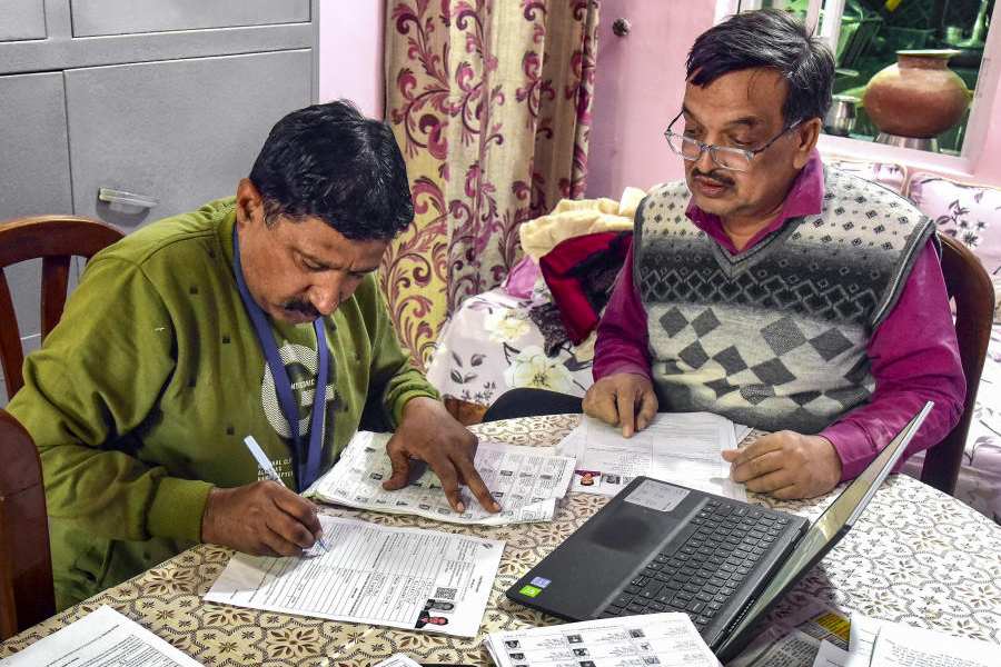 A Booth Level Officer (BLO) assists a voter in filling out the enumeration form for the special intensive revision (SIR) of electoral rolls, in Bikaner, Rajasthan, Sunday, Nov. 16, 2025.