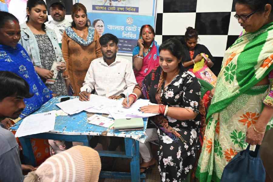 Trinamool Congress workers help people fill in their enumeration forms in Burdwan on Sunday.