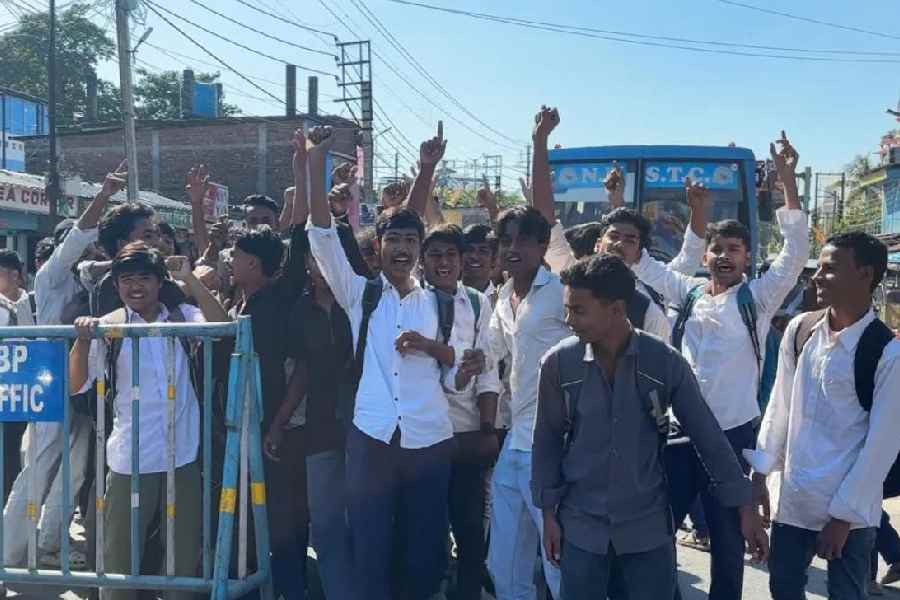 Class X students of Islampur High School block the state highway on Wednesday.
