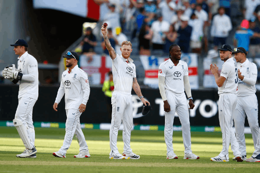 England's captain Ben Stokes, center, raises the ball after taking five wickets during the first Ashes cricket test match between Australia and England in Perth, Friday, Nov. 21, 2025.