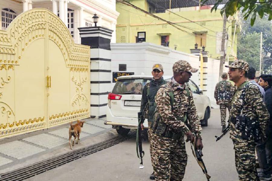 Security personnel stand guard outside a property during the ED raid in Dhanbad on Friday. 
