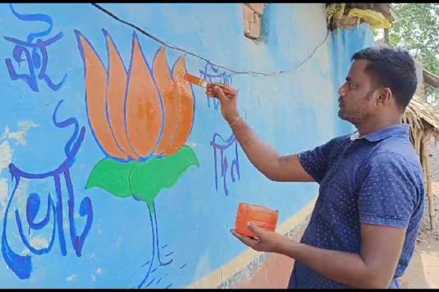 A BJP worker painting graffiti on the wall for Panchayat Elections on 18.06.2023.