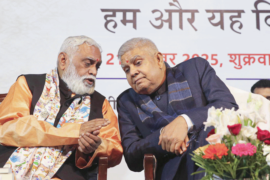 Former vice president Jagdeep Dhankar, right, and RSS leader Manmohan Vaidya during the release of the latter’s book titled 'Hum Aur Yeh Vishwa', in Bhopal, Friday, Nov. 21, 2025.