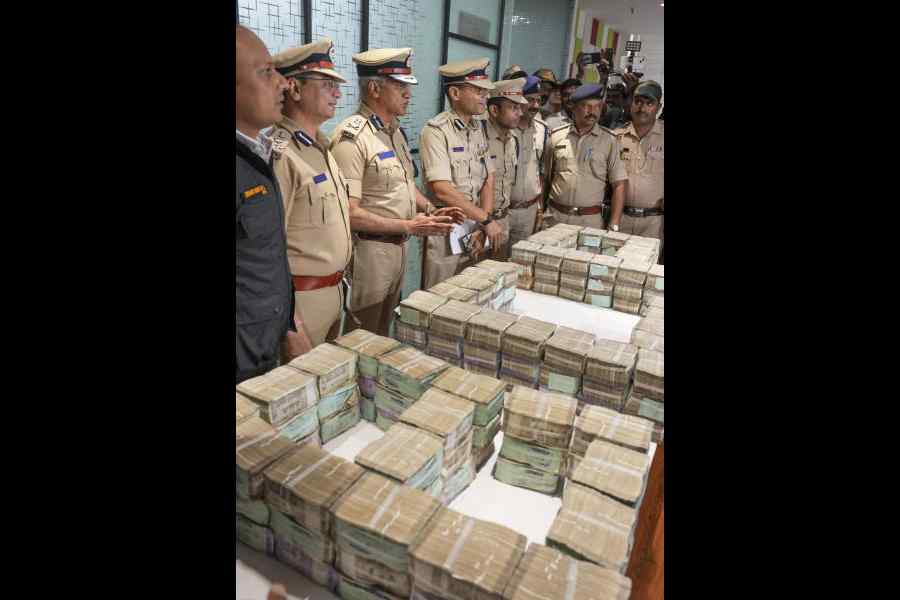 Police officials with the cash that was stolen from the ATM van in Bengaluru on Saturday.