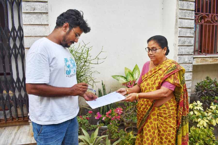 A BLO collects an enumeration form from a woman in Nabadwip.