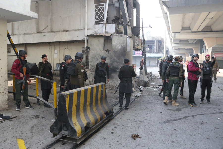 Army and paramilitary soldiers secure the entrance of the headquarters of a Pakistani paramilitary force after suicide bombers targeted it in Peshawar, Pakistan, on November 24, 2025.