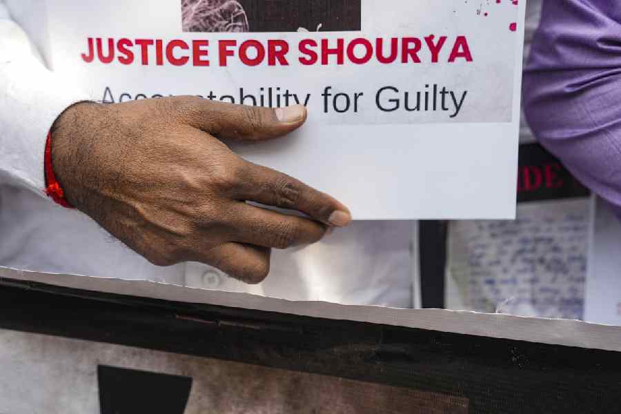 An agitator holds a placard during a protest by school students and parents of a Class 10 student, who allegedly died by suicide due to mental harassment, demanding strict action against those responsible, outside St Columba's School, in New Delhi, Monday, Nov. 24, 2025.