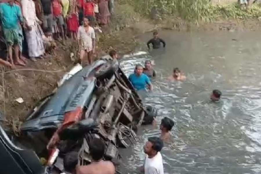 The car being fished out of the pond in Uluberia on Monday