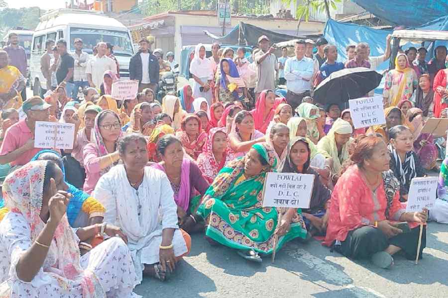 Workers of the Dalsinghpara tea estate block Asian Highway 48 near Jaigaon in Alipurduar district on Monday.