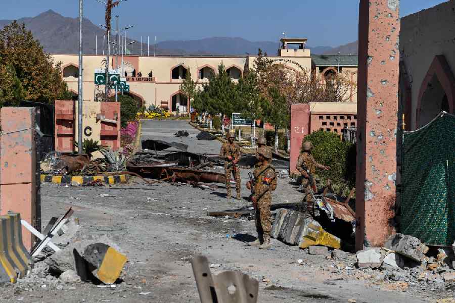 Army soldiers stand guard next to a damaged area at the main gate of an army-run cadet college that was assaulted by militants on Monday, in Wana, a city in the northwestern Pakistani district South Waziristan bordering with Afghanistan, Thursday, Nov. 13, 2025.