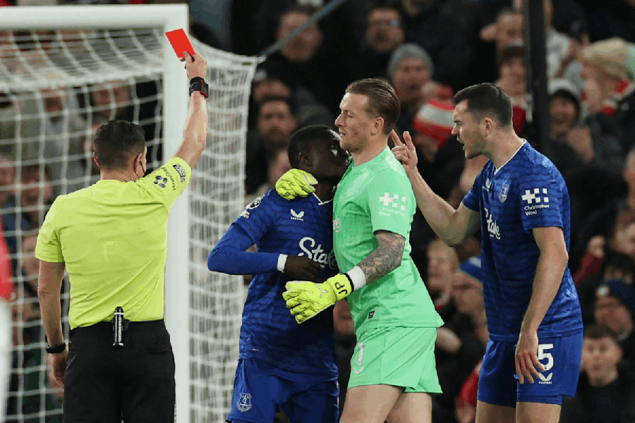 Everton's Idrissa Gueye is held back by Everton's Jordan Pickford as he clashes with teammate Michael Keane and shown a red card by referee Tony Harrington.