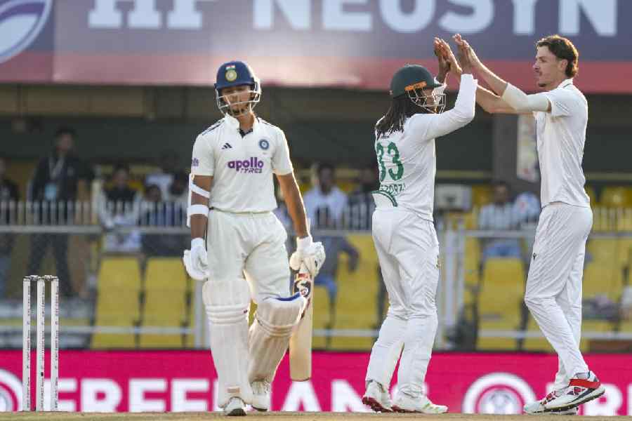 India's Yashasvi Jaiswal, left, walks off after being dismissed as South African's players celebrate, right, during the fourth day of the Test cricket match between India and South Africa at the Barsapara Cricket Stadium, in Guwahati