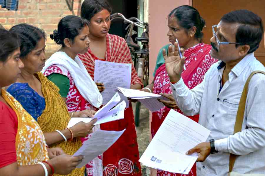 Nadia: A booth level officer (BLO) explains the details of enumeration forms to voters