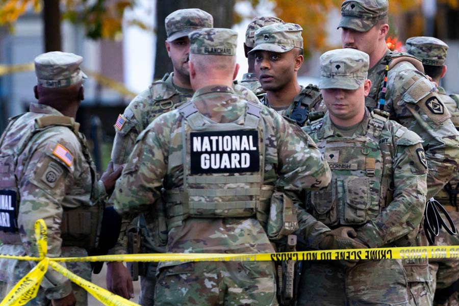 National Guard members stand together behind yellow tape, after two National Guard members were shot near the White House in Washington, D.C., U.S., November 26, 2025.
