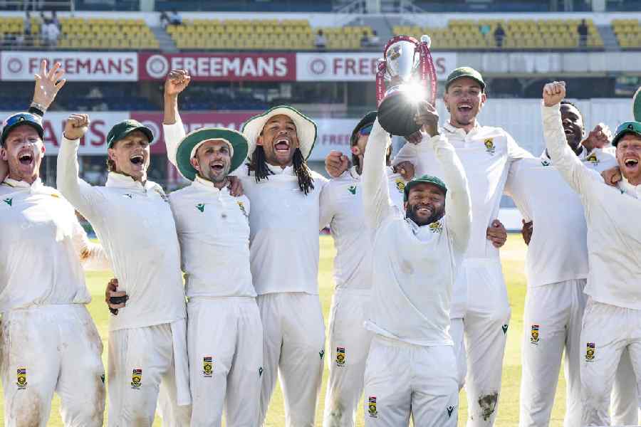 South Africa's players celebrate with the trophy at the end of the fifth day of the second Test cricket match between India and South Africa, at ACA Stadium, Barsapara in Guwahati
