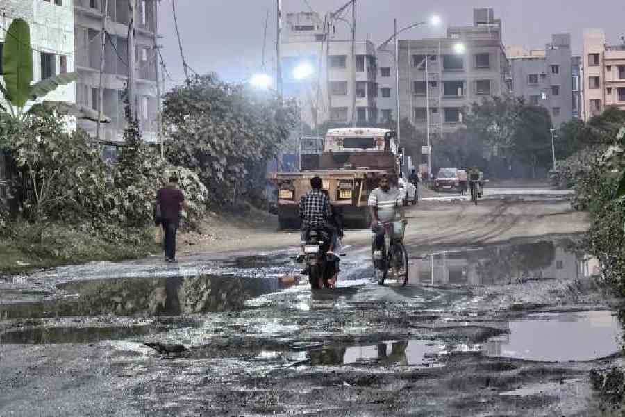 The remains of the top bitumen layer on Street 757, in front of an under-construction  complex, that leads to Alaktika Housing Complex in Action Area IID on Wednesday. Pictures by Sudeshna Banerjee