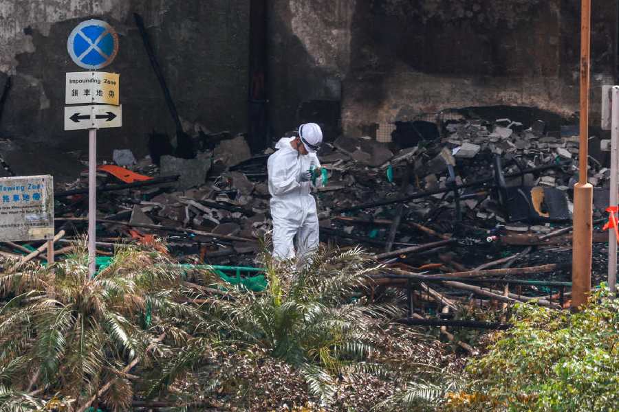 A police officer holds a sample at the site of a fire-damaged residential block at Wang Fuk Court housing complex in Tai Po, Hong Kong