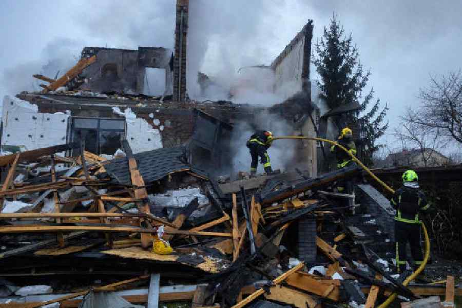 Firefighters work at the site of a private home that went up in flames after it was hit by a Russian drone in Kyiv on Saturday. 