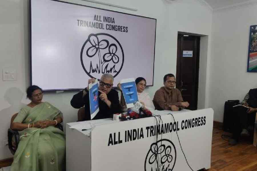 TMC MPs Derek O’Brien and Sajda Ahmed hold up placards at the media conference on Saturday