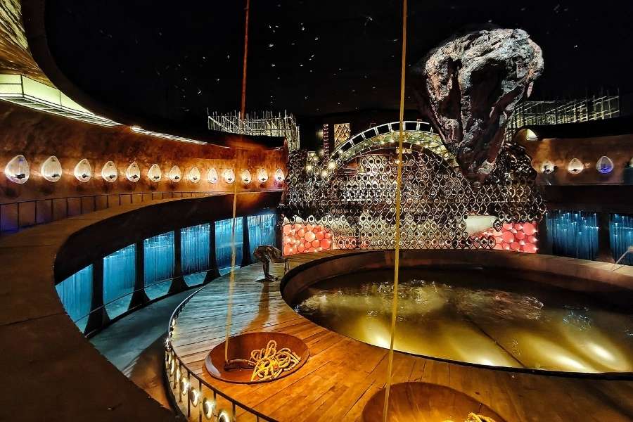 Under the theme ‘Proshno’, the pandal at Rajdanga Naba Uday Sangha  rises like a cosmic stage, inspired by the Shivlinga and surrounded by the ocean of creation