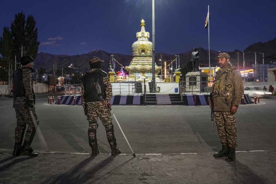 Security personnel stand guard on a road after the end of a seven-hour relaxation in the curfew, in Leh, Tuesday, Sept. 30, 2025.