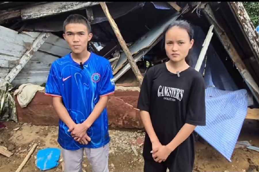 Siblings Niten and Arnima in front of their ravaged home in Mirik.