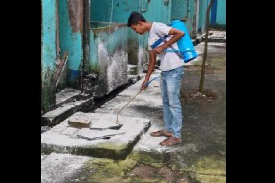 A health worker spreads larvaecide in the ESI Housing Complex after the incident.