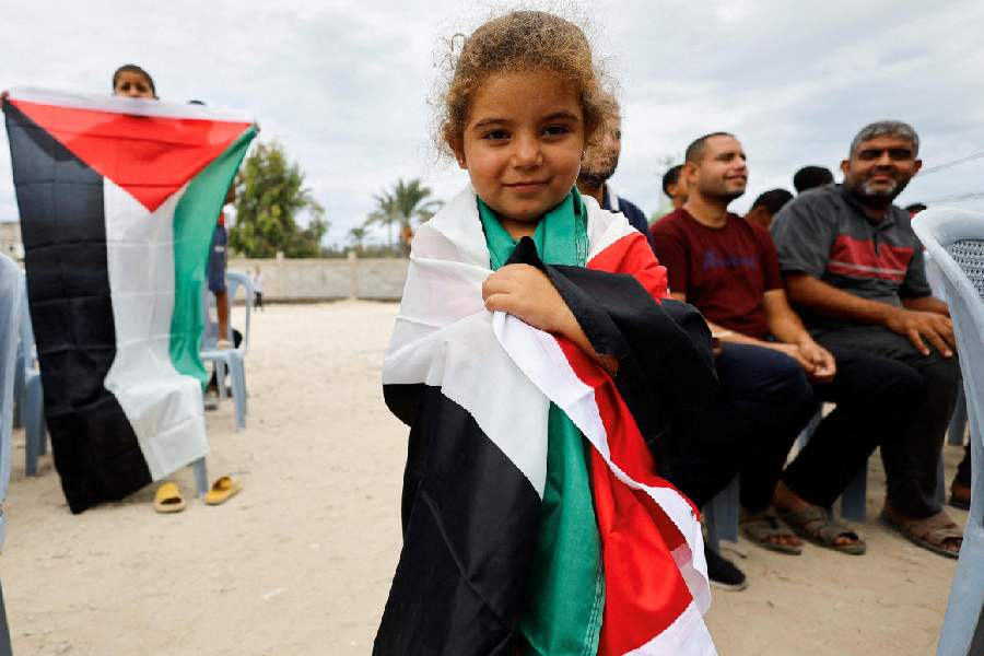 A girl wraps herself in a Palestinian flag in the central Gaza Strip on Thursday. 