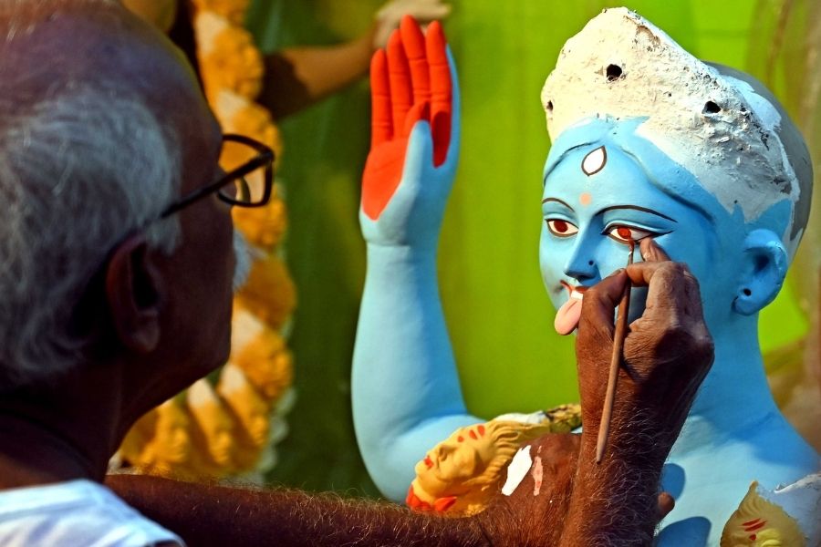 An artist paints the eyes of the Kali idol