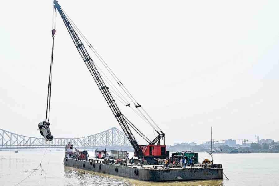 A crane on a barge lifts the WagonR out of the river on Thursday. Picture by Sanat Kr Sinha