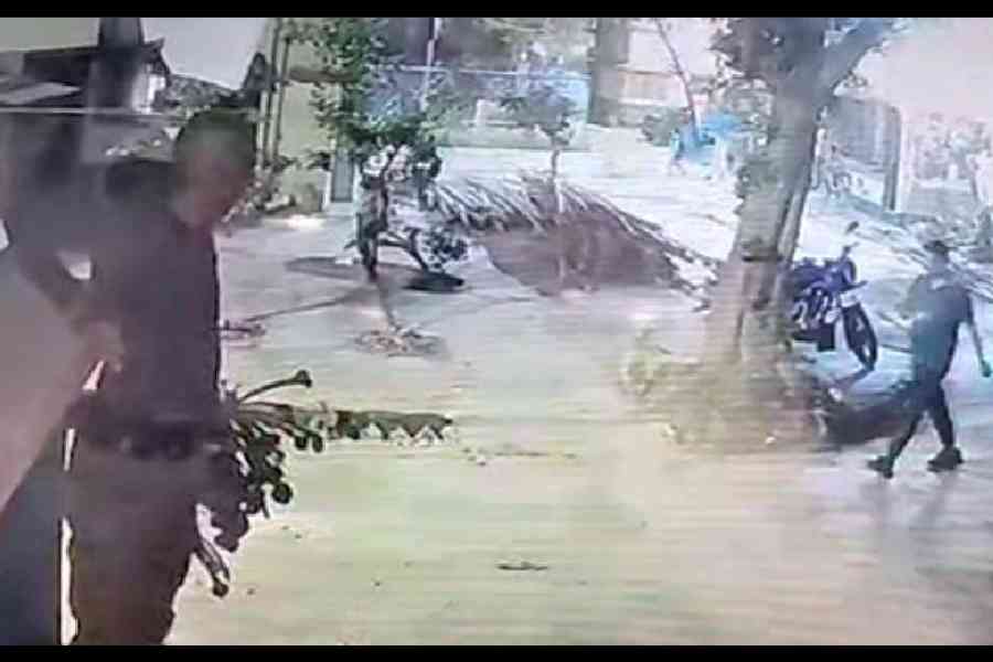 A still from CCTV footage shows a man preparing to jump from the cornice  of the housing complex