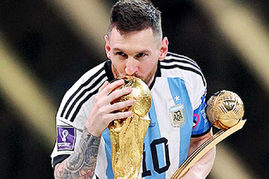 Argentina's Lionel Messi with the World Cup and the Golden Ball award in the 2022 Qatar World Cup.