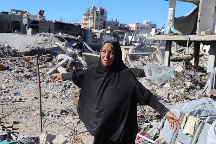A Palestinian woman, Hayam Meqdad, 49, walks on the rubble of her destroyed home, in Gaza City