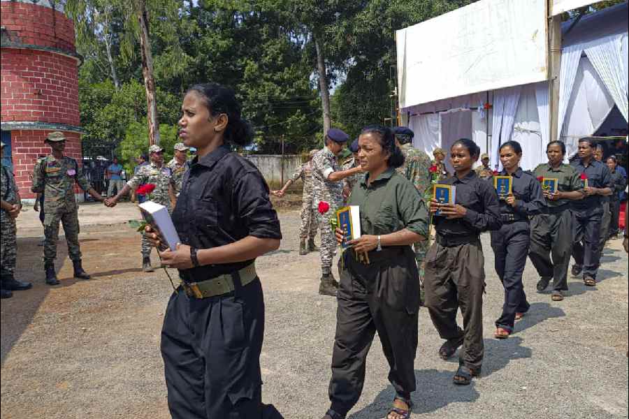 Naxalites hold copies of the Constitution of India after their surrender at the police lines, Jagdalpur, in Bastar district, Chhattisgarh, Friday, Oct. 17, 2025.