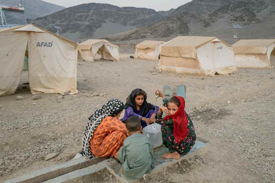 Afghan children wash their hands in the Omari refugee camp on September 15, 2025 in Torkham, Afghanistan.
