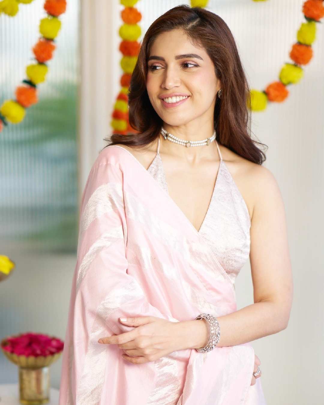 The Royals actress Bhumi Pednekkar twirled in a soft pink lehenga. She posed with garlands and rose petals for a picture.  