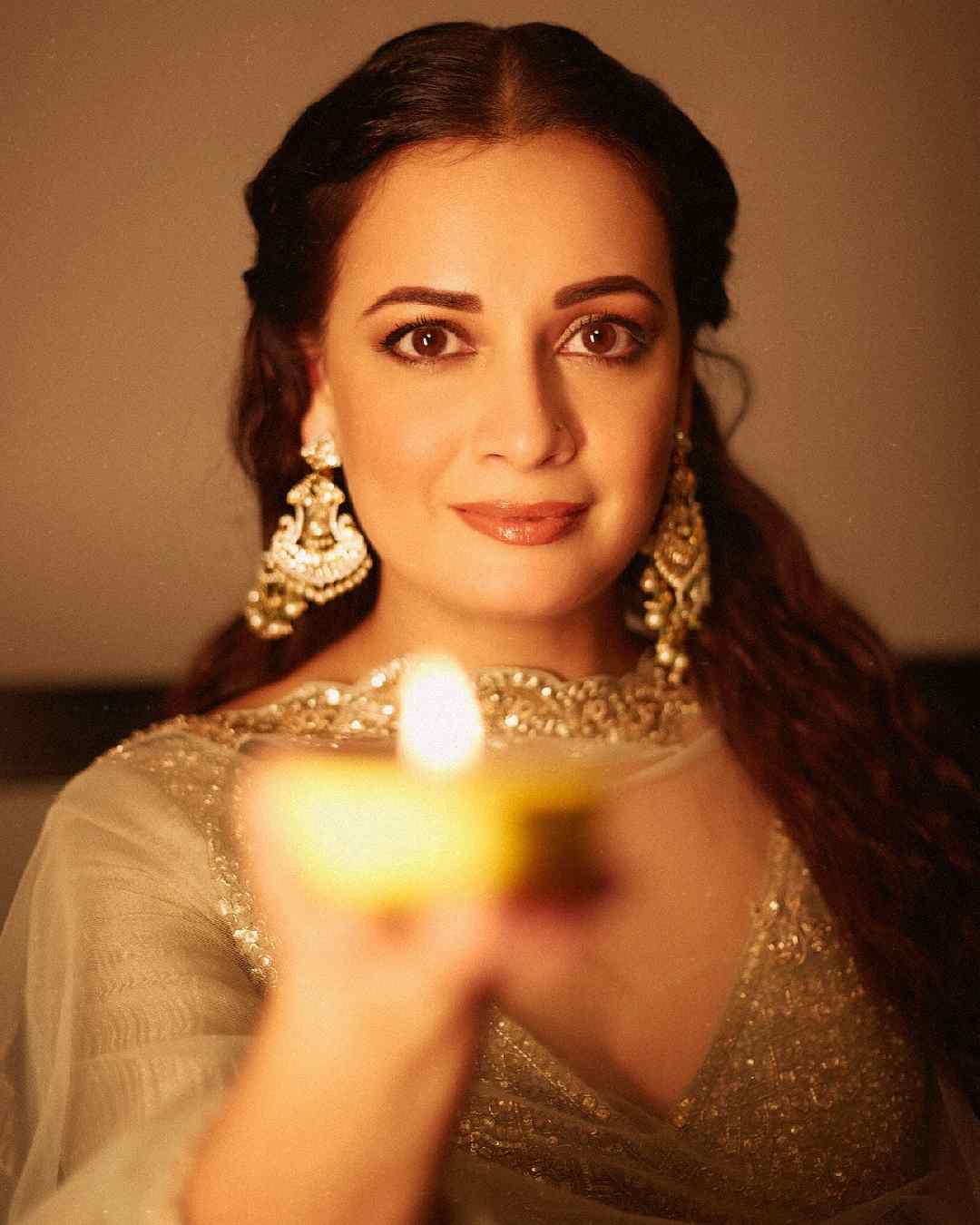 Actress Dia Mirza posed with a diya in her hand. She looked gorgeous in a green organza lehenga. Dewy makeup and danglers elevated Dia’s festive look.  