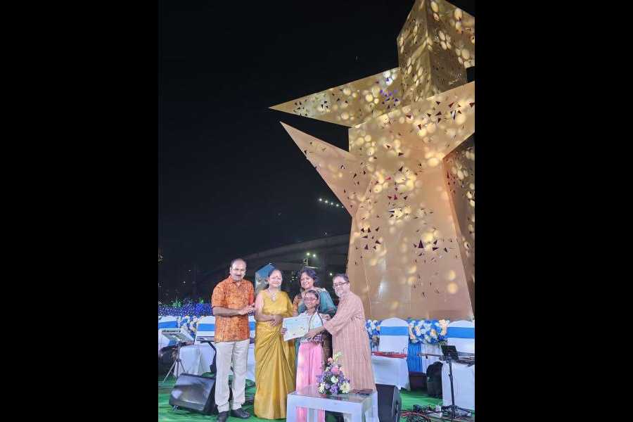 The trophy being handed to Aishani Das of Moonbeam by Air Chief Marshal Arup Raha (Retd.). Also present are Meghna Pal of NKDA (second from right) and the judge Ashoke Mullick (right)